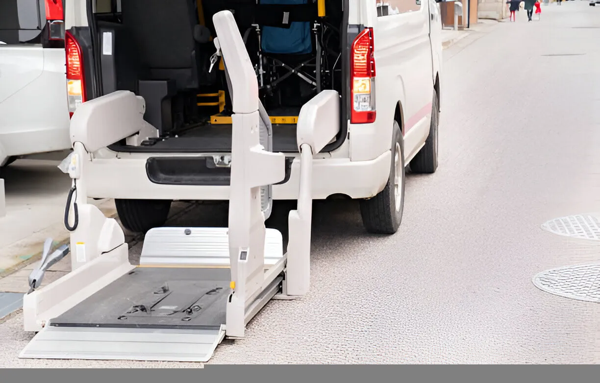 Professional disabled taxi with hydraulic ramp at hospital entrance.
