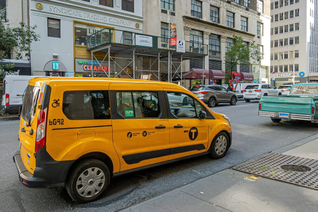 NYC wheelchair taxi with driver assisting wheelchair user in New York City