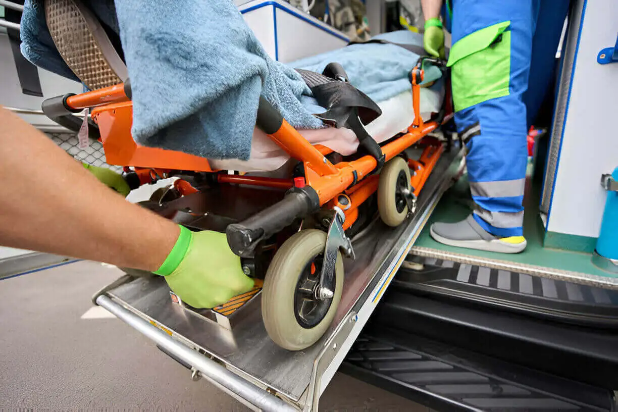 Patient on stretcher being loaded into ambulette