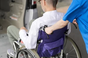 Wheelchair transportation services near me showing ADA van with ramp and driver assisting passenger