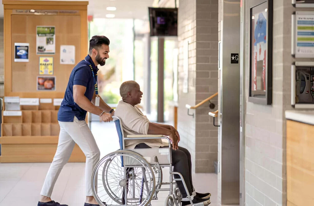 Caregiver helping elderly rider into NYC wheelchair transportation vehicle
