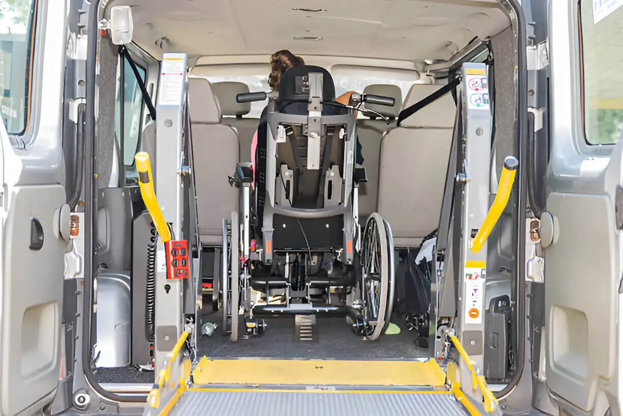ADA-compliant van with wheelchair lift being used by passenger for safe entry