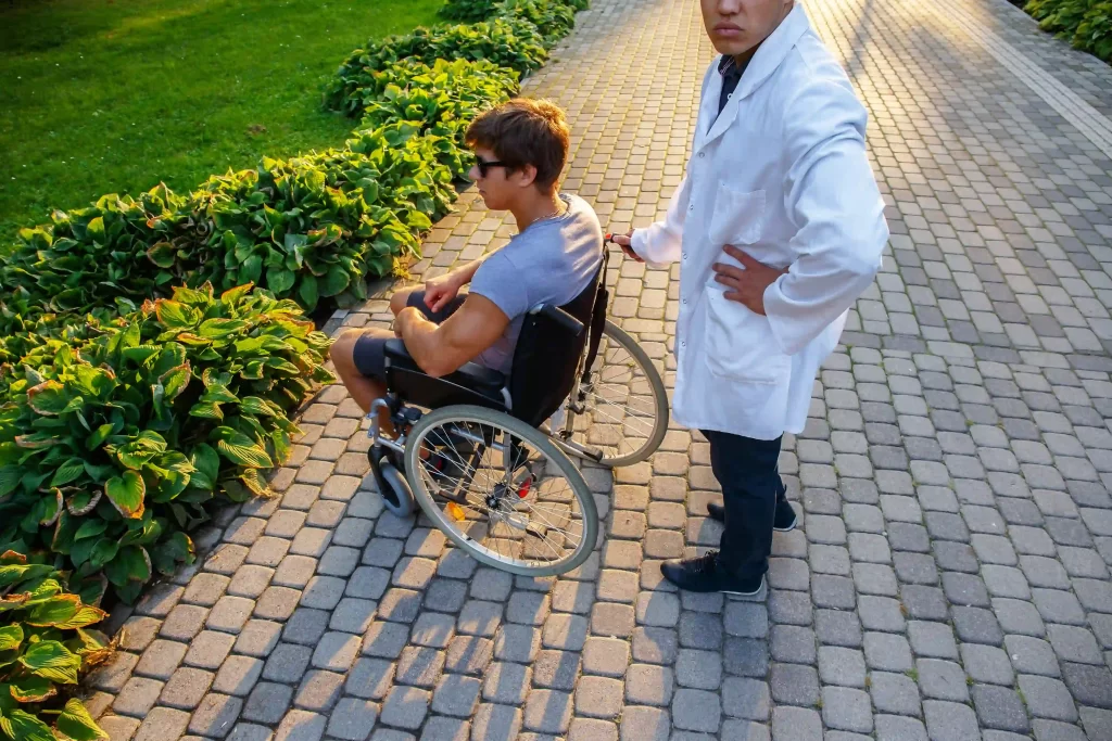 young-man-in-wheelchair-and-his-doctor-outside-2023-11-27-05-34-46-utc-1024x683